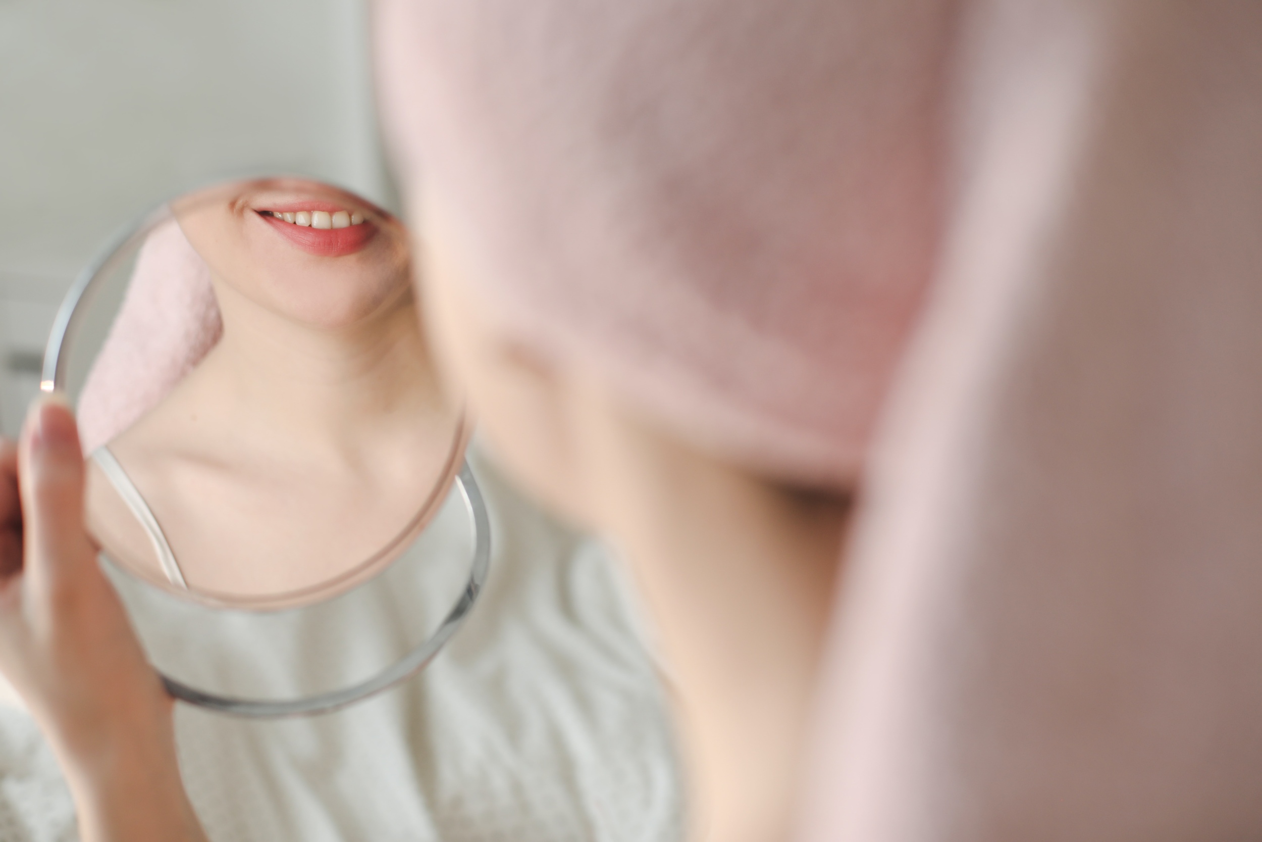 Transparente Zahnschiene wird mit beiden Händen auf die oberen Zähne eingesetzt.