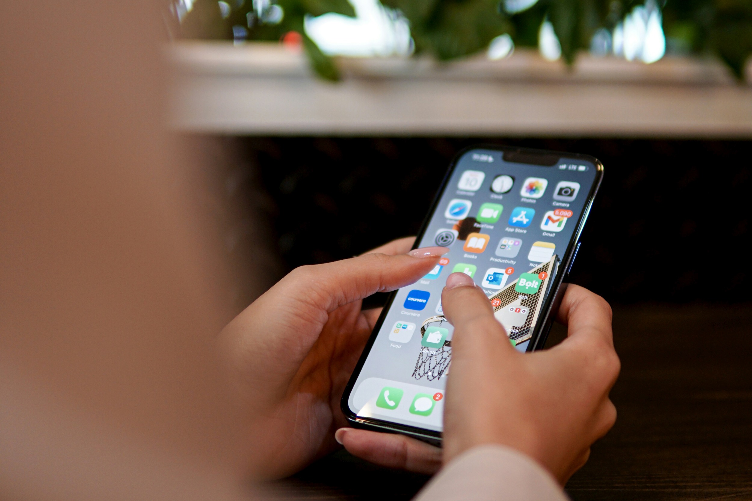 Hand hält Smartphone mit eingeschaltetem Bildschirm.